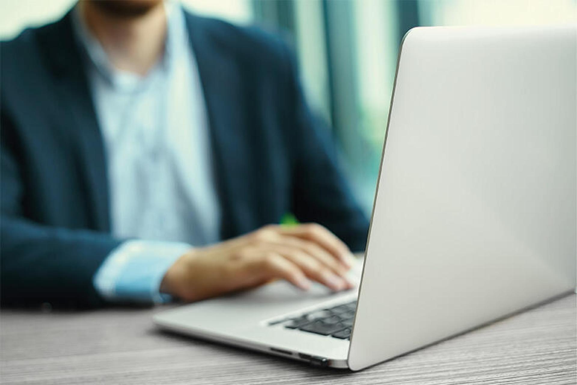 Photo illustrant un homme sur un ordinateur portable