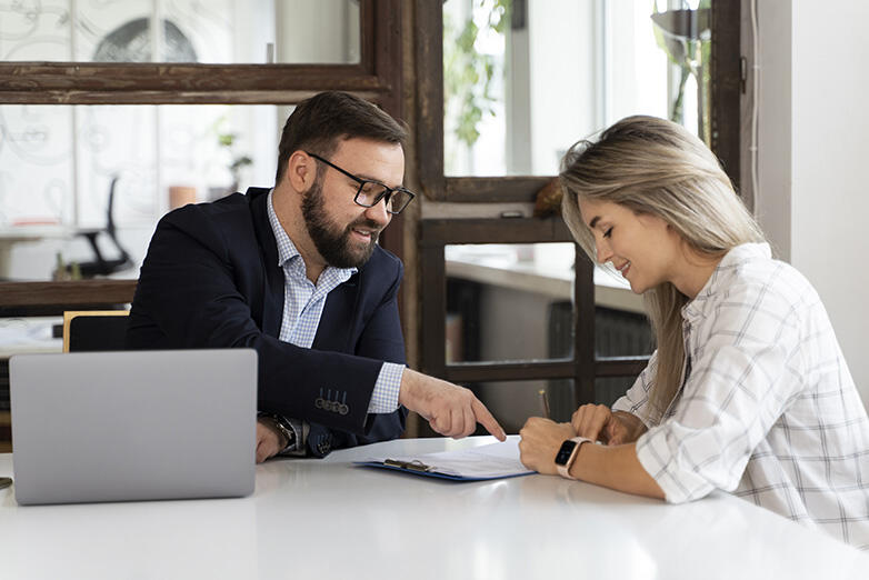 Photo illustrant deux personnes au travail devant un contrat